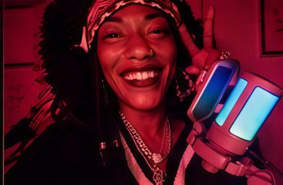 Chief I'ni MichElle.magic live in the red-lit studio, moment 1 of 4